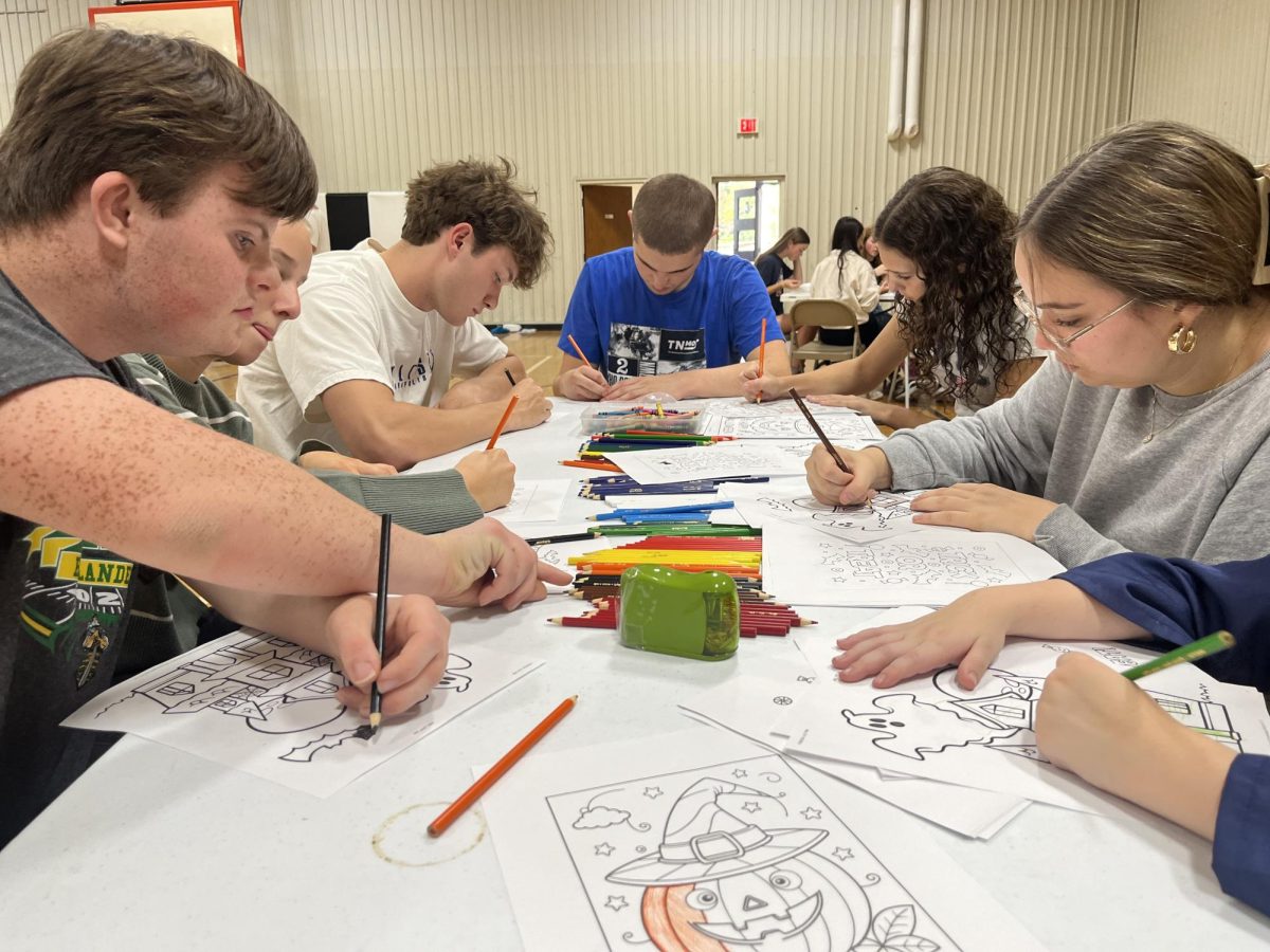 Best Buddies members color Halloween pictures together during their October meeting.
