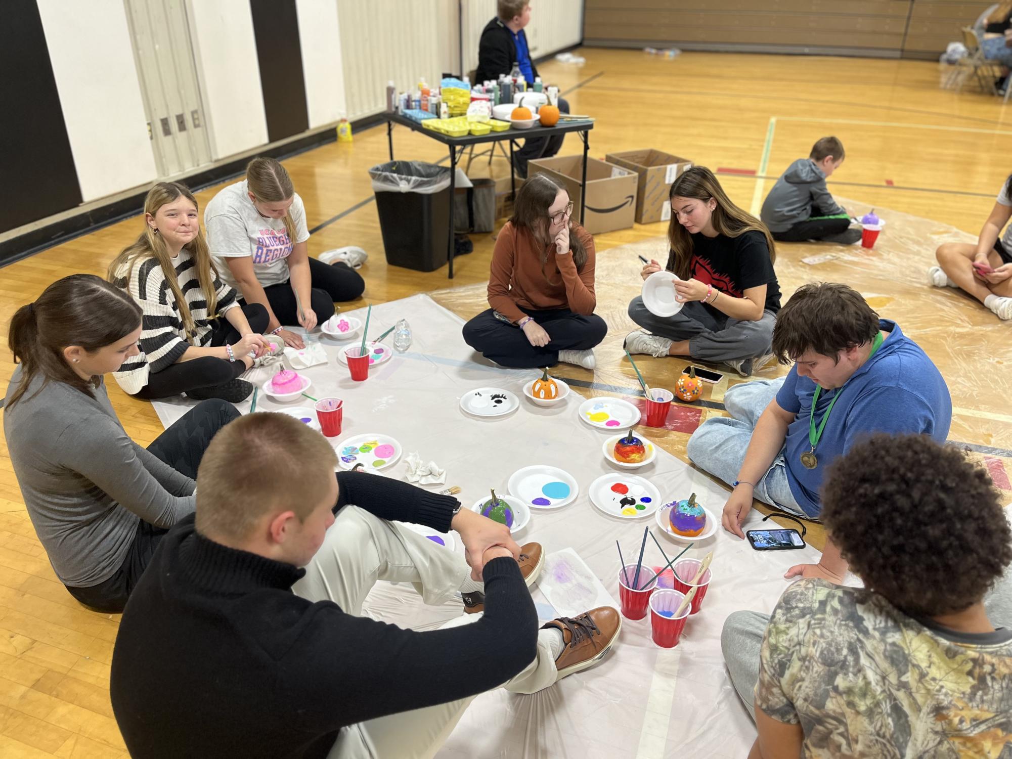 Students in the Best Buddies club work together to paint pumpkins during their party before Fall Break.