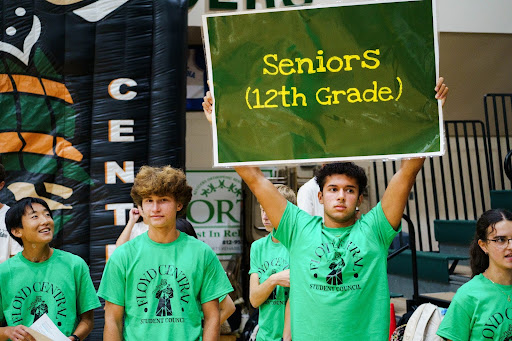 Senior Ryan Cochran holds up a sign directing students to their section during the fall homecoming pep rally. Both Cohran and senior Alex Eichenberger are members of Floyd Central's student council. 