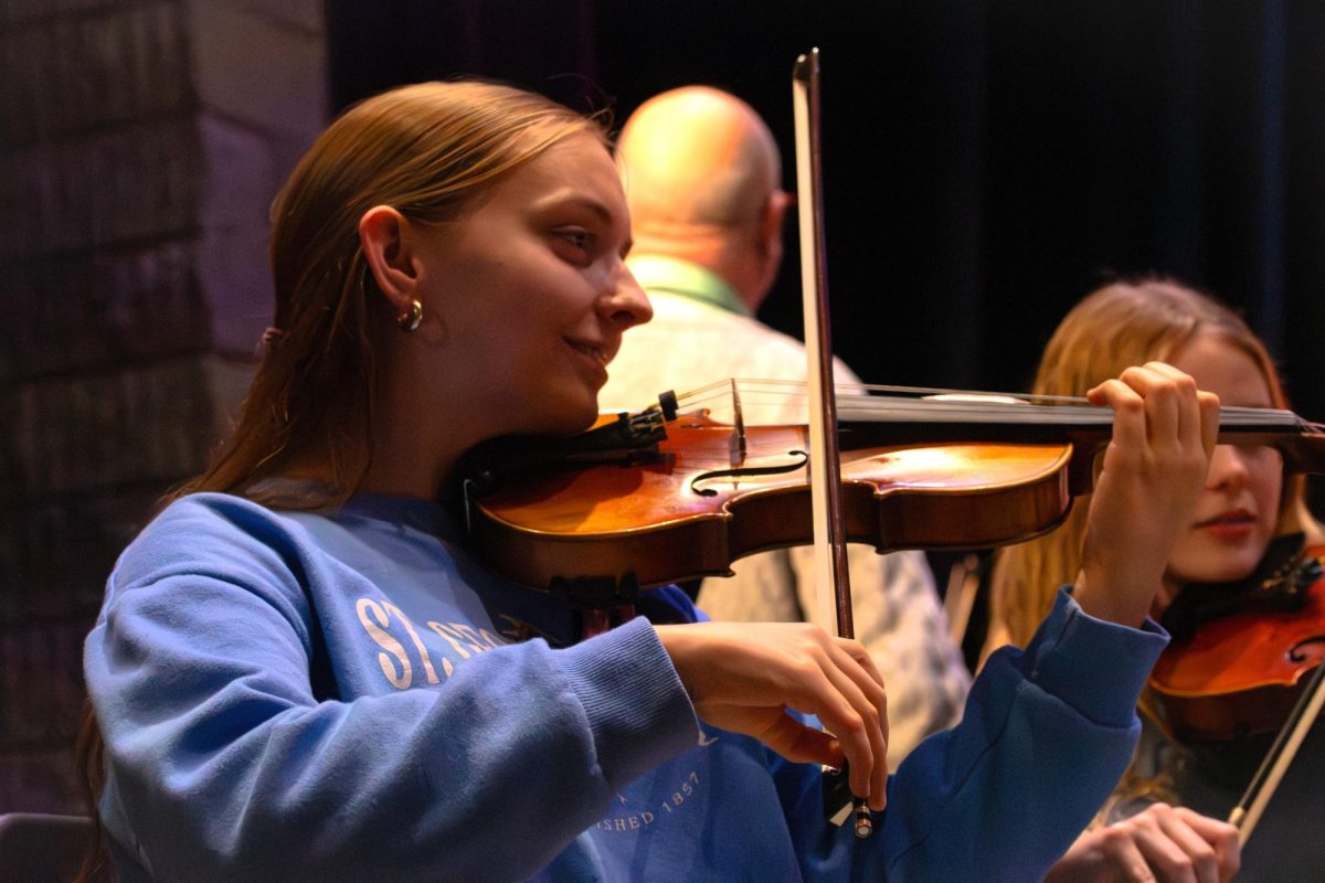 Senior Emma Phillips plays the violin for the orchestra during Winter Fantasia rehearsal Monday night.