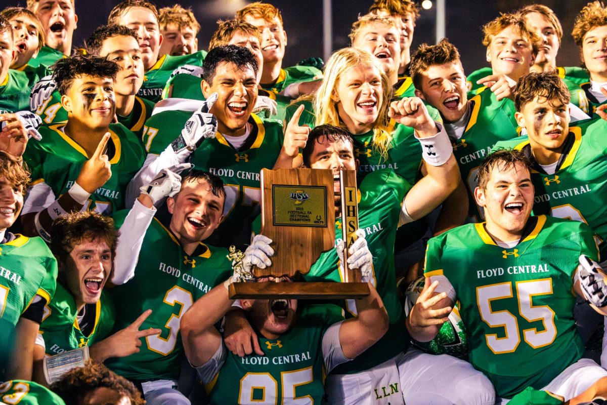 The football team celebrates their victory with the sectionals trophy after the big game.