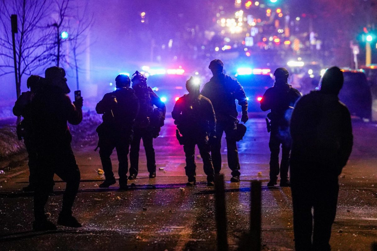 Federal agents stand guard after deploying tear gas as community members protest after federal law enforcement agents were involved in a shooting incident, a week after a U.S. Immigration and Customs Enforcement (ICE) agent fatally shot Renee Nicole Good, in Minneapolis, Minnesota, U.S., January 14, 2026. REUTERS/Ryan Murphy