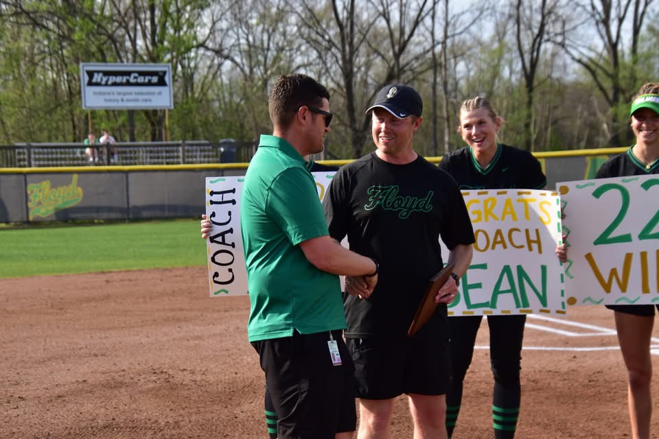 Softball coach Sean Payne shakes hands with athletic director Chris Kane.